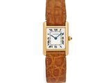 an 18k yellow gold cartier tank watch with alligator leather strap