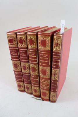 six livres rouges sont empilés les uns sur les autres sur une surface blanche