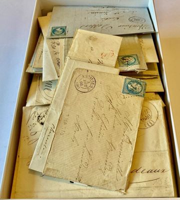 une boîte remplie de vieilles lettres et d'enveloppes posée sur une table