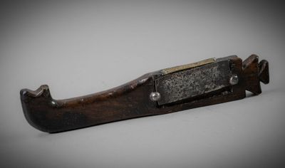 a close up of a knife with a metal handle on a white surface