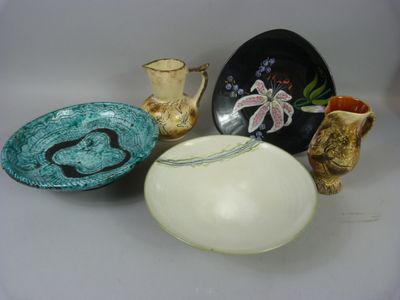 trois bols et deux vases posés sur une table