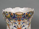 a close up of a vase on a table with a gray background
