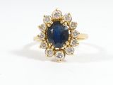 a close up of a ring with a sapphire and diamonds