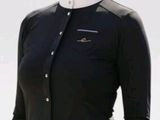 smiling woman in a black shirt and white pants posing for a picture