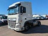 un camion blanc garé sur un parking avec d'autres camions