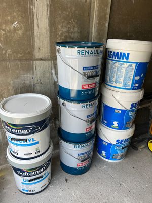 several buckets of paint sitting on the floor next to each other
