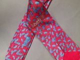 a red tie with blue leaves on it laying on a table