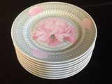 une pile d'assiettes ornées d'une fleur rose