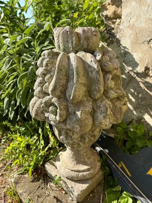 une statue représentant une tête posée sur un rocher, à côté d'un livre