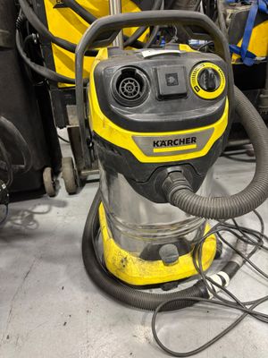 un aspirateur jaune et noir posé par terre dans une pièce