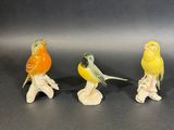 three small figurines of birds sitting on top of each other