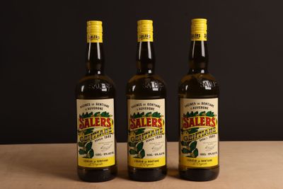 trois bouteilles d'huile d'olive posées sur une table en bois