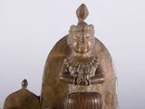 a wooden statue of a woman sitting on a barrel