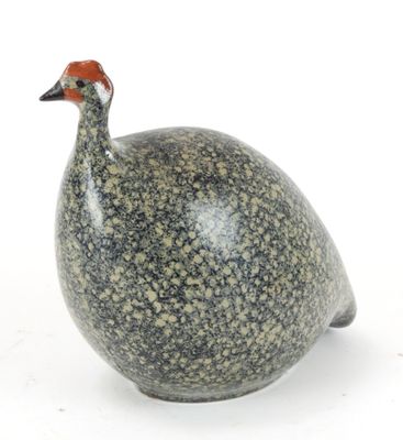 un petit oiseau perché sur une surface blanche