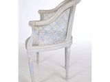 a white chair with a wicker back and a blue seat