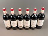 six bottles of red wine lined up in a row