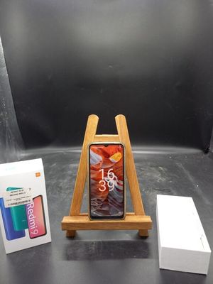 un téléphone posé sur un support à côté d'une boîte
