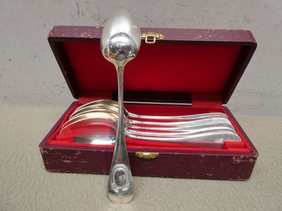 une cuillère en argent et une cuillère en argent dans une boîte rouge