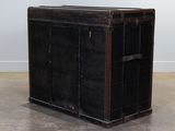 a black trunk sitting on the floor in a room
