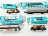 cinq wagons de train miniature différents et une boîte d'allumettes