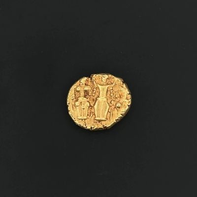 a close up of a gold coin on a black surface