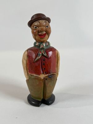 a figurine of a man wearing a hat and vest