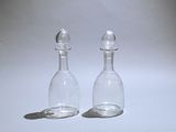 pair of clear glass salt and pepper shakers on a white surface