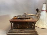 an old record player sitting on top of a table next to a cone