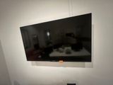 a flat screen tv mounted on the wall above a bed