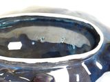 a close up of a blue vase on a white surface
