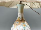 a lamp that is sitting on a table with a lamp shade on it