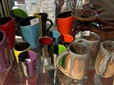 de nombreuses tasses de différentes couleurs exposées dans une vitrine