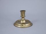 an antique brass candle holder on a white background