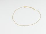 un bracelet en chaîne d'or orné d'un seul diamant sur fond blanc