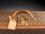 a brown suitcase with a tag on top of it