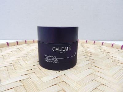 caudale firming cream in a black jar on a woven basket