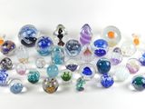 de nombreuses perles de verre de différentes couleurs sur un fond blanc