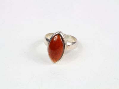 une bague en argent avec une pierre rouge au centre
