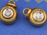 une paire de boucles d'oreilles en or et diamants sur fond bleu