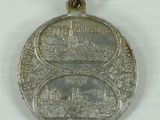 an old silver medal with a picture of a castle on it