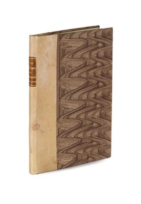 un vieux livre à la couverture brune posé sur une surface blanche