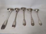 six spoons and a spoon rest in a row on a table