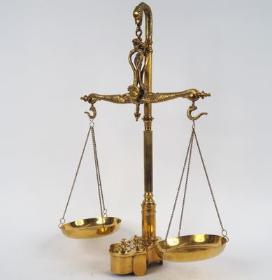 une image représentant une balance en or comportant deux plateaux