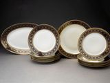 cinq assiettes ornées de bordures dorées et d'un motif noir et blanc