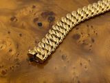 gold chain bracelet on a wooden box on a white background