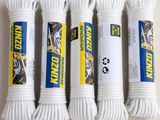 Trois cordons blancs de type « paracord » sont disposés sur une table