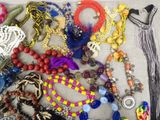 a lot of different colored beads and necklaces on a table