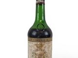 une vieille bouteille de vin posée sur une surface blanche