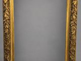 un miroir à cadre doré orné d'un motif de feuilles