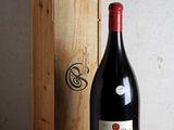 une bouteille de vin posée sur une table à côté d'une caisse en bois